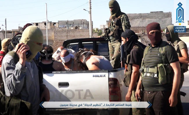 This July 9, 2017 photo, released by Ibaa news agency, the communications arm of the al Qaeda-linked Levant Liberation Committee, outlet that is consistent with independent AP reporting, shows al-Qaida-linked fighters after they detained alleged members of the Islamic State group in the northwestern Syrian village of Sarmin in Idlib province. (AP)