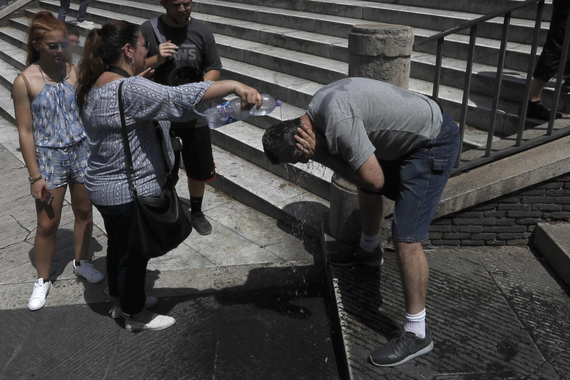 A man has water pour over his head in Rome, Thursday, Aug. 3, 2017. Italy's heat wave has pushed the mercury to levels as high as 40 degrees Celsius (104 Fahrenheit). (AP)