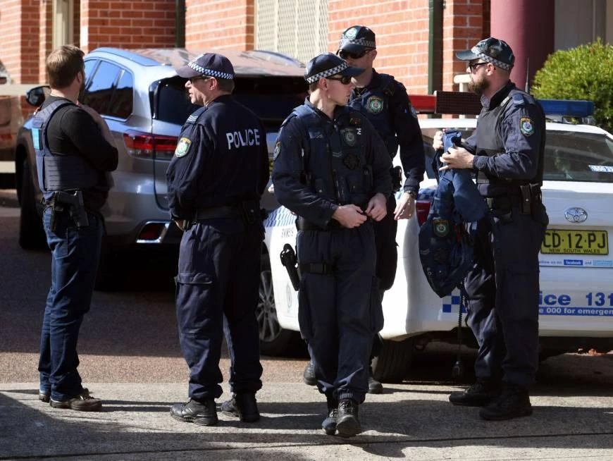 Police emerge from a block of flats in the Sydney suburb of Lakemba on Tuesday after counterterrorism raids across the city over the weekend. Four men accused of plotting to bring down a plane planned to use poisonous gas or a crude bomb disguised as a meat mincer, reports said on Sunday, with Australian officials calling preparations 'advanced. (AFP)