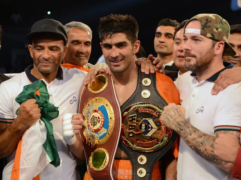 Indian boxer and WBO Asia-Pacific Super Middleweight champion Vijender Singh (C) celebrates after winning the double title bout against China's Zulpikar Maimaitiali at the National Sports Complex of India (NSCI) Dome in Mumbai on August 5, 2017. / AFP / PUNIT PARANJPE