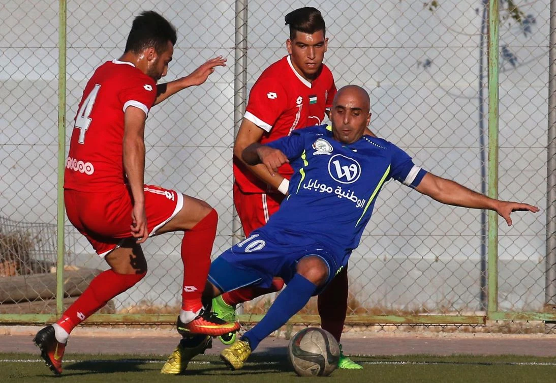 A player from the Gaza-side Shabab Rafah football team (blue) kicks the ball as Hebron's Ahly Al-Ahli players defend during the second leg of the Palestinian Cup final at the stadium in the city of Dura, near the West Bank town of Hebron, on August 4, 2017. Shabaab Rafah are taking on Ahly al-Khalil without 10 of their 25-man squad after Israel denied transit permits. (AFP)