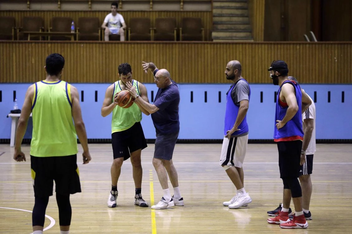 Serbian coach Ninad Karzis (C) talks to a player during a training session of the Syrian basketball team in Damascus on July 17, 2017. Since Syria's conflict erupted in March 2011, basketball player, Khalil Khoury, has seen his team's ranks dwindle and its options for training venues shrink. But it still practises and competes, including in the prestigious FIBA Asia Cup championship to held on August 17-27 in neighbouring Lebanon. Among the league's biggest challenges has been retaining talent, with players emigrating, doing their military service, or being injured or killed in the conflict. (AFP)