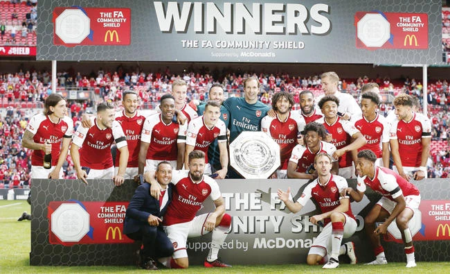 Arsenal players with the Community Shield trophy as they celebrate victory after the English FA Community Shield football match between Arsenal and Chelsea at Wembley Stadium Sunday. (AFP)