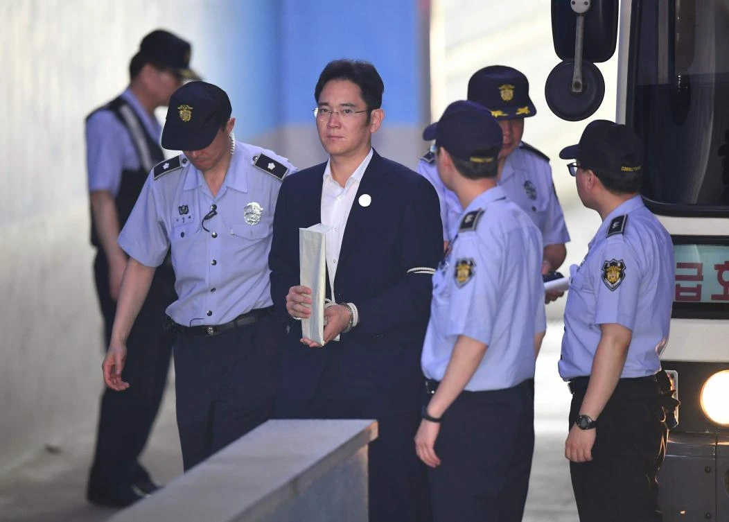 Lee Jae-Yong (C), the vice-chairman of Samsung Electronics, is escorted by prison guards as he arrives at the Seoul Central District Court in Seoul on August 2, 2017. The heir to the world's top smartphone maker Samsung was expected to take the stand on August 2 to be questioned by prosecutors in an epic corruption trial involving ousted South Korean president Park Geun-Hye. / AFP / JUNG Yeon-Je