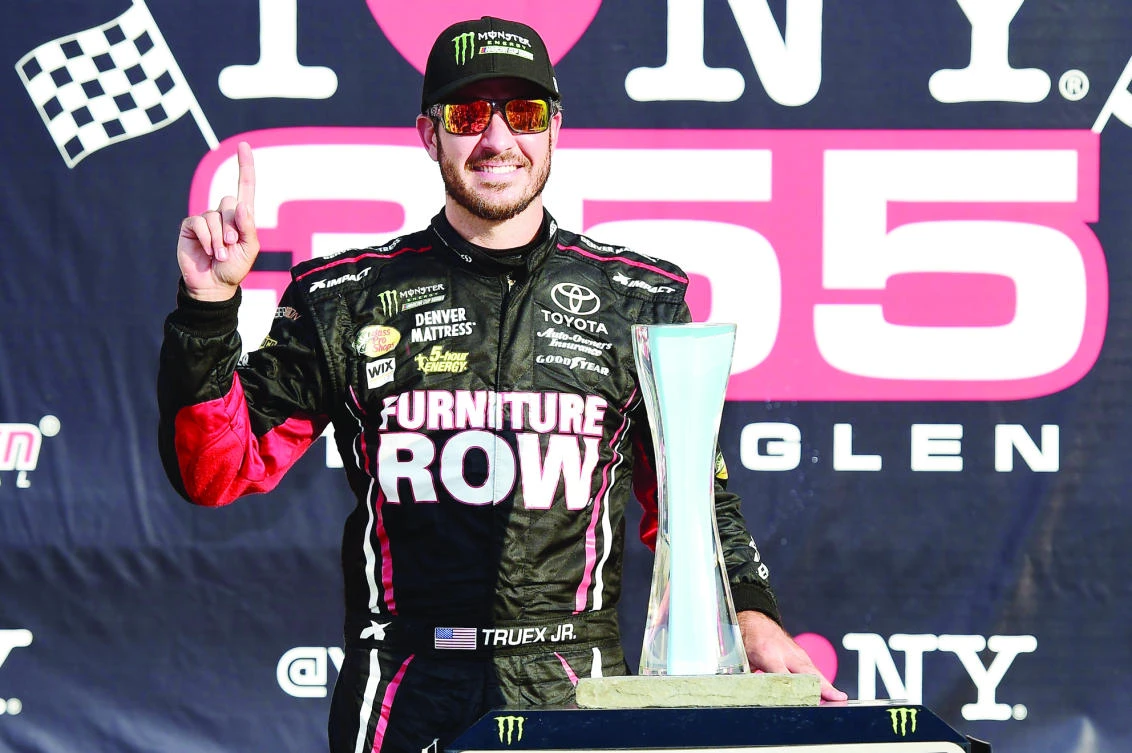 Martin Truex Jr., driver of the #78 Furniture Row/Denver Mattress Toyota, celebrates in victory lane after winning the Monster Energy NASCAR Cup Series I Love NY 355 at The Glen at Watkins Glen International on Sunday. (AFP)