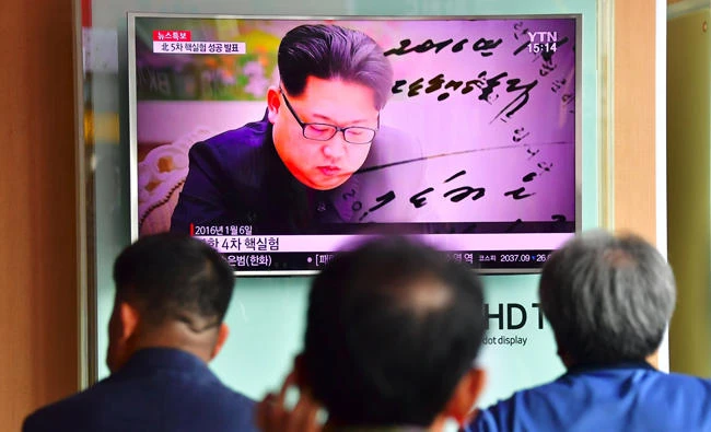 This file photo taken on September 09, 2016 shows people watching a television news report, showing file footage of North Korean leader Kim Jong-Un, at a railway station in Seoul. (AFP / Jung Yeon-Je)