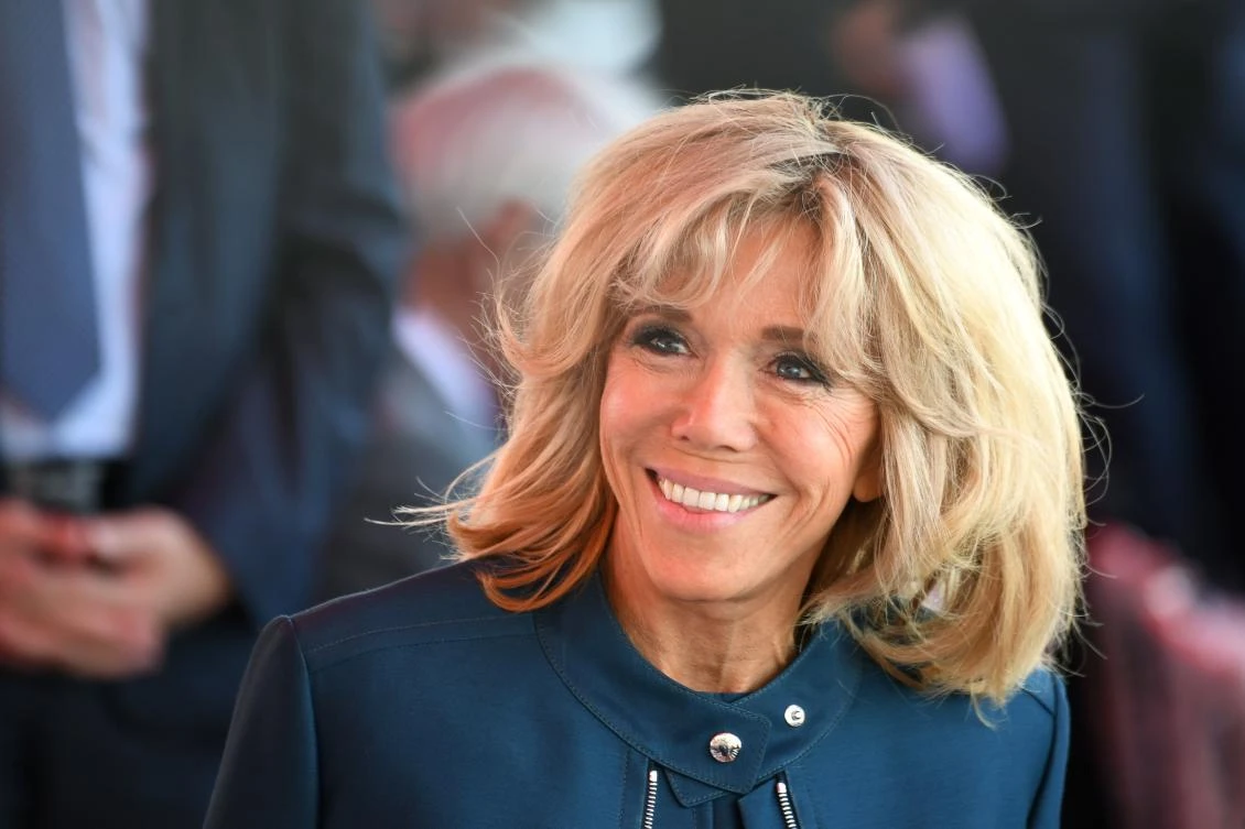 FILES - This file photo taken on July 14, 2017 shows Brigitte Macron (C), wife of French President, smiling ahead of the start of the annual Bastille Day military parade on the Champs-Elysees avenue in Paris. French President Emmanuel Macron is preparing to backpedal on the issue of creating an official First Lady position for his wife amid attacks from left-wing opponents and a petition against the move, officials and reports said on August 7, 2017. (AFP)