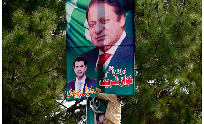 A Pakistani worker installs a huge billboard of deposed Prime Minister Nawaz Sharif on the planned route of his rally at a highway in Islamabad, Pakistan, on Tuesday. According to Malik Mohammad Ahmed, a spokesman in Punjab where Lahore is the provincial capital, Sharif planned to travel with a convoy of supporters by road on Wednesday from the capital, Islamabad to Lahore. (AP Photo/ Anjum Naveed)