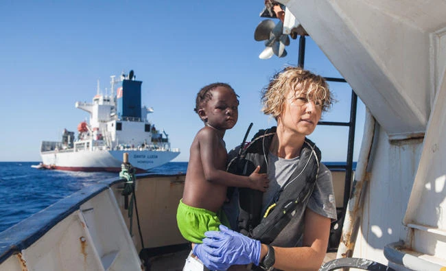 A Spanish nurse of Proactiva Open Arms NGO carries a child rescued from the Mediterranean Sea aboard the Golfo Azzurro ship, operated by Proactiva about 15-miles north of Al Khums, Libya, on Tuesday. (AP Photo/Anna Surinyach)