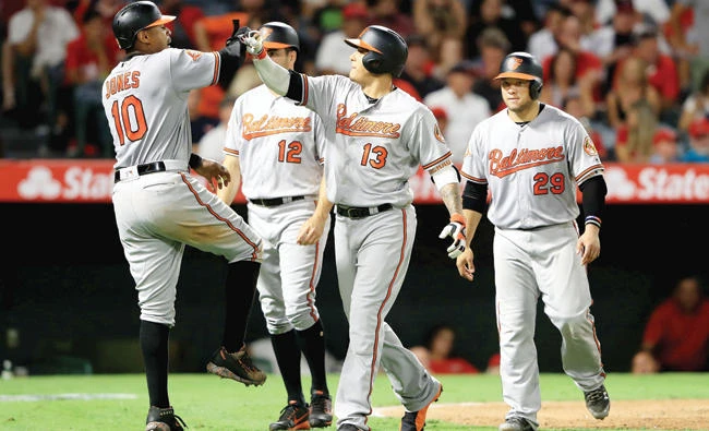 Adam Jones (10), Seth Smith (12) and Welington Castillo (29) congratulate Manny Machado (13) of the Baltimore Orioles after he hit a grand slam during the seventh inning of a game against the Los Angeles Angels of Anaheim on Monday. (AFP)