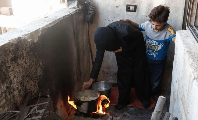 A Syrian woman prepares a meal using mushrooms in the fighter-held town of Douma. (AFP)