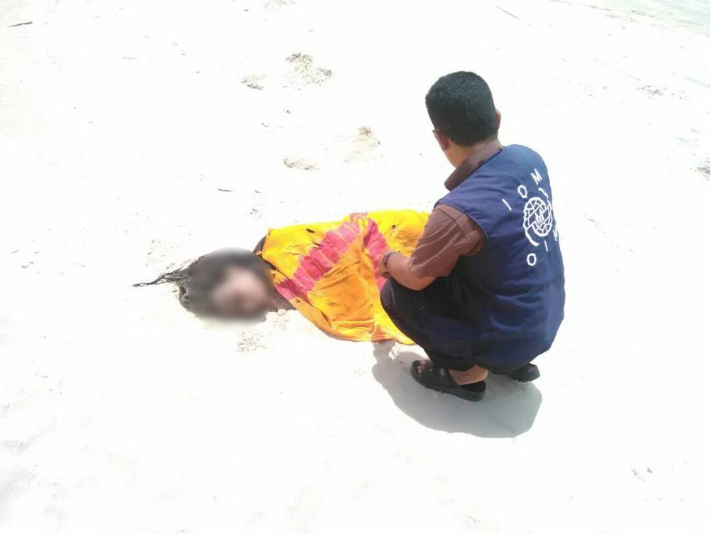IOM staff tend to the remains of a deceased migrant on a beach in Yemen. (UN Migration Agency (IOM) 2017)
