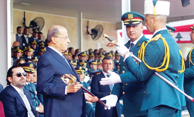 Lebanese President Michel Aoun hands out a sword to a Lebanese officer cadet during his graduation parade at a military academy marking the 72nd Army Day in Fayadyeh, near Beirut, on Aug. 1. (Reuters)