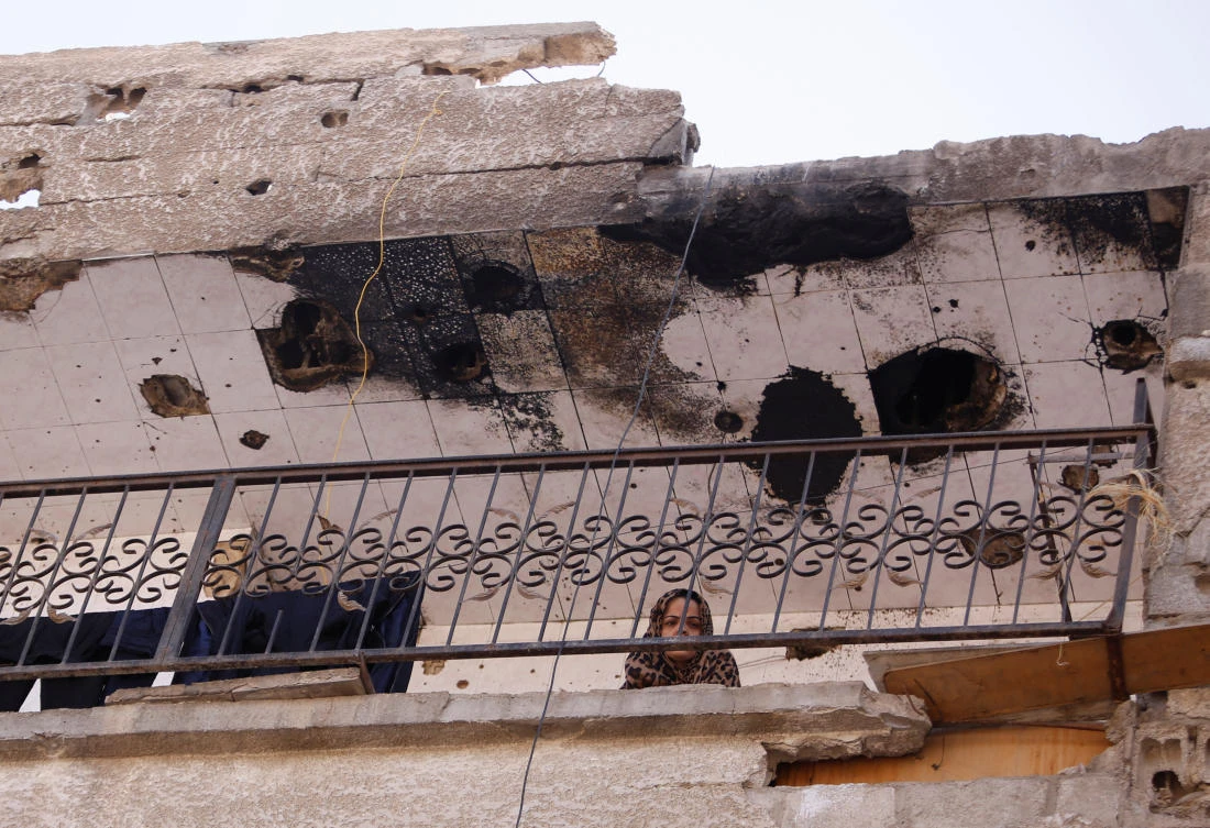 A woman is seen at a balcony in Moadamiya, in Damascus, Syria July 23, 2017. Picture taken July 23, 2017. (REUTERS)