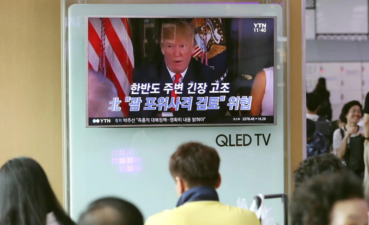 People watch a TV screen showing a local news program with an image of U.S. President Donald Trump, at Seoul Train Station in Seoul, South Korea, Wednesday, Aug. 9, 2017. North Korea and the United States traded escalating threats, with President Donald Trump threatening Pyongyang "with fire and fury like the world has never seen" and the North's military claiming Wednesday it was examining its plans for attacking Guam. The letters read "North Korea, Examine, the enveloping fire at Guam." (AP)