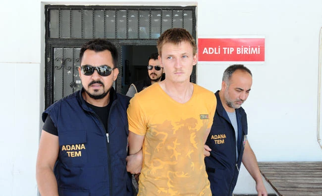 A Russian national suspected man is escorted by Turkish anti terror police officers on Thursday during a medical check in Adana. (AFP)