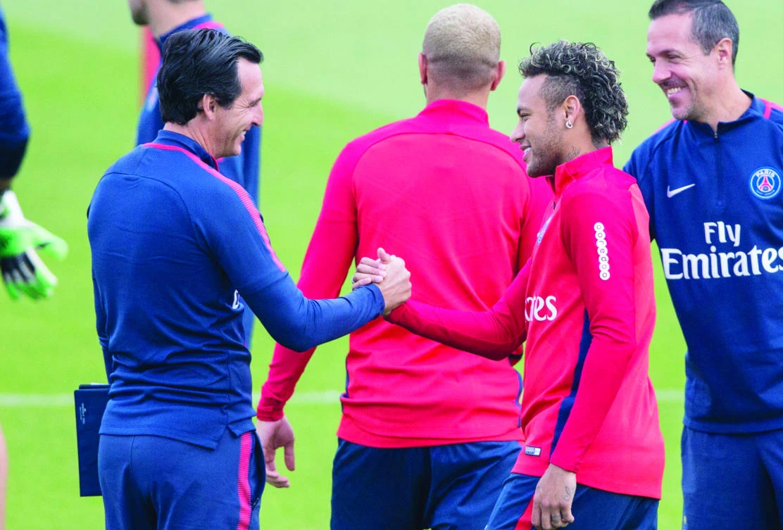 Paris Saint-Germain’s coach Unai Emery, left, greets Neymar during a training session in Saint Germain en Laye, France, on Friday. (AP)