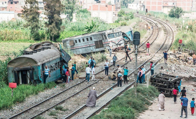 People observe the wreckage of Friday’s fatal train collision on the outskirts of Egypt’s Mediterranean city of Alexandria from the day before. (AFP)