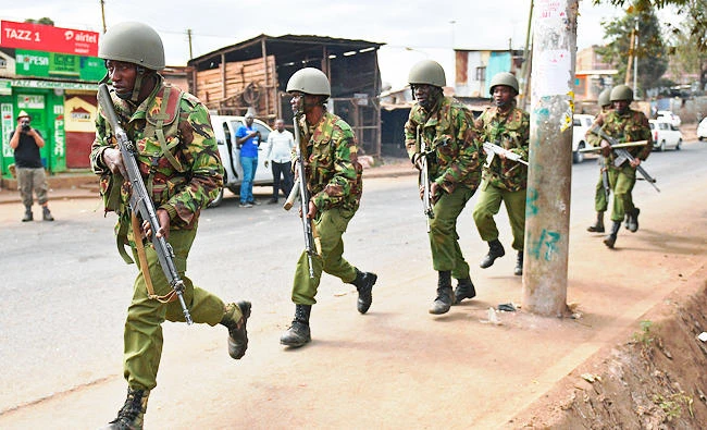 Armed Kenyan police run to disperse protesters in the Kibera slum in Nairobi on Saturday. (AFP)