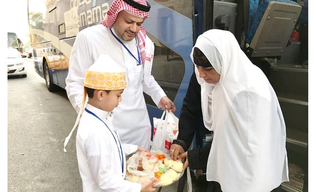 A Saudi official welcomes Hajj pilgrim with sweets and Zamzam water at the Prophet’s Mosque in Madinah. (SPA)