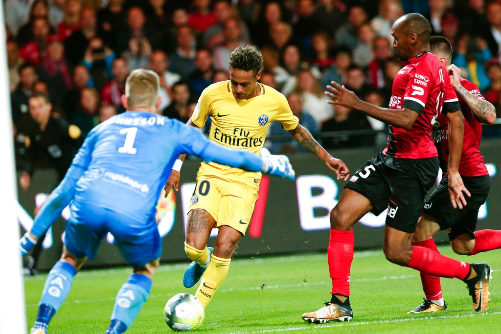 PSG's Neymar, center, tries to score past Guingamp goalkeeper Karl-Johan Johnsson, left, during the French League One soccer match between Guingamp and PSG at the Roudourou stadium in Guingamp, western France, Sunday, Aug. 13, 2017. Neymar makes his long-awaited debut with Paris Saint-Germain on Sunday in the small Brittany town of Guingamp. (AP)