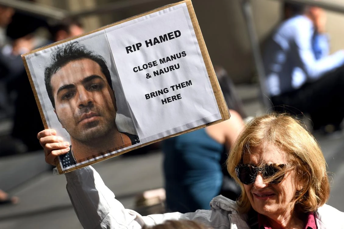 A member of a human rights group holds a placard as they call for an independent inquiry outside the Commonwealth Government offices in Sydney on August 9, 2017, after another refugee was found dead at a detention camp in Papua New Guinea in a tragedy they said was preventable. Australia's Human Rights Law Centre said Hamed Shamshiripou was the fifth held on Manus Island to die since Canberra's offshore regime began in July 2013. (AFP)