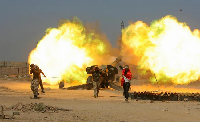 In this Sunday, May 29, 2016 file photo, Iraqi security forces and allied Popular Mobilization forces fire artillery during fight against Daesh militants in Fallujah, Iraq. Iraq's mostly Shiite militia forces say they will participate in the next major battle against Daesh in Iraq after victory was declared in Mosul last month. (AP Photo/Anmar Khalil, File)