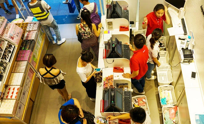 Customers pay bills inside a store in Shanghai on Tuesday. (AFP)