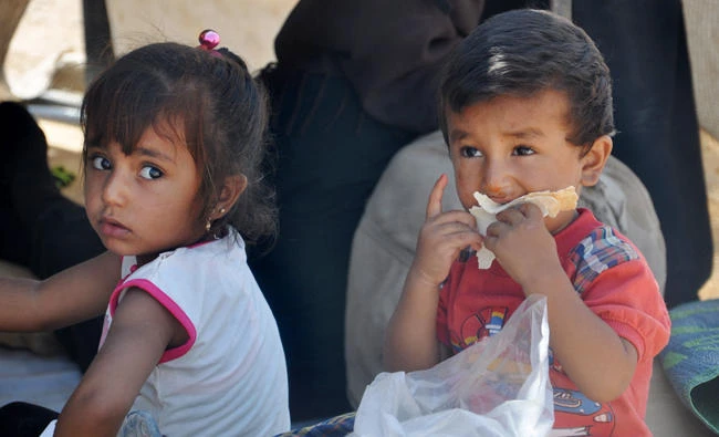 Displaced Syrian children from Deir Ezzor take shelter at a make-shift camp some seven kilometers from Arisha in the neighboring province of Hasakah on Aug. 13. The camp is dominated by young men who fled Deir Ezzor after Daesh began imposing enlistment in the last Syrian province that remains nearly completely under its control. (AFP)