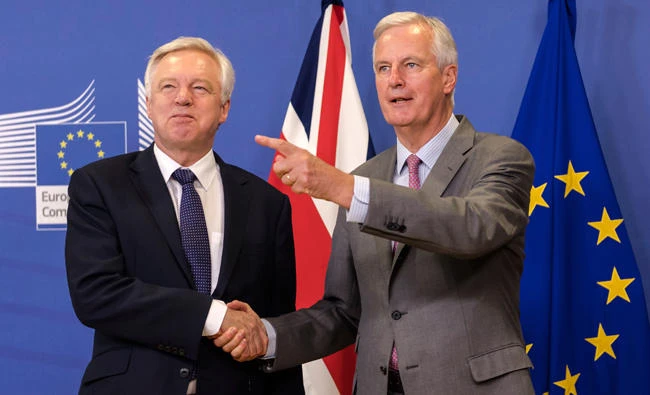 File photo shows EU chief Brexit negotiator Michel Barnier, right, welcoming British Secretary of State, David Davis, for a meeting at the EU headquarters in Brussels. (AP)