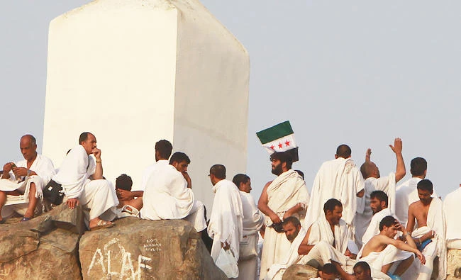 A Syrian opposition flag is seen as Muslim pilgrims climb Mount Mercy on the plains of Arafat, during the peak of the annual hajj pilgrimage near the holy city of Makkah, in this file photo. (REUTERS)