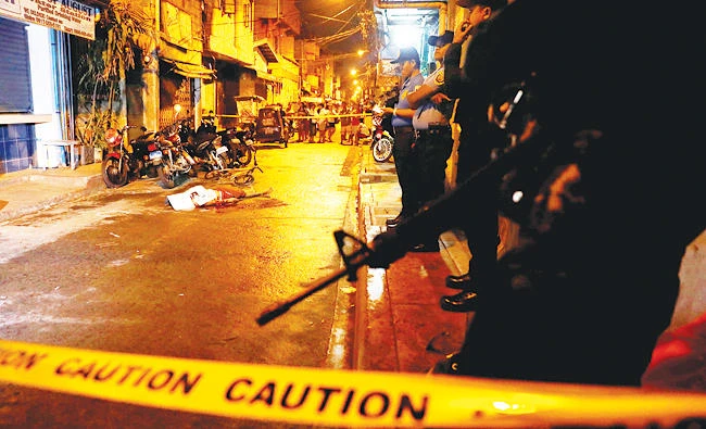 Policemen stand guard near the body of a man killed during what police said was a drug related vigilante killing in Pasig, Metro Manila, Philippines, in this February 1, 2017 photo. (Reuters)