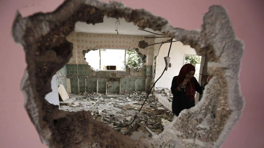 A woman checks the remains of the house of a Palestinian man, who killed three Jewish residents of a nearby Israeli settlement, after it was demolished by Israeli authorities in Kobar, August 16, 2017. (FP)