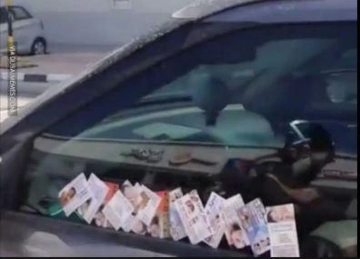 “Massage” service cards left on a car in Dubai (YouTube)