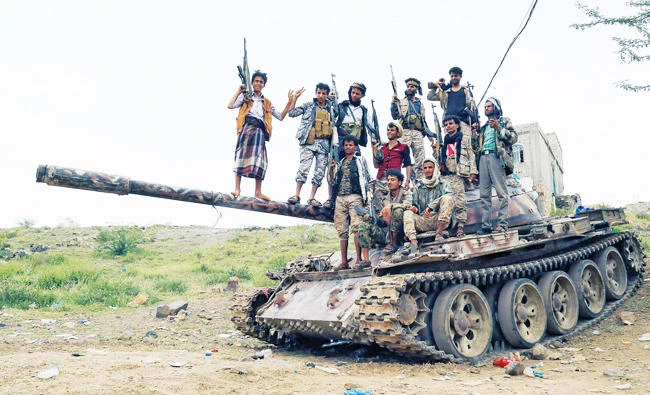 Pro-government fighters stand on the barrel of a tank in an area where they fought against Houthi militants in the southwestern city of Taiz, Yemen. (Reuters)