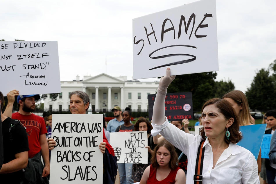 Protesters hold signs in front of the White House in Washington, U.S. to protest the weekend's violence in Charlottesville, VA, August 14, 2017. (Reuters)
