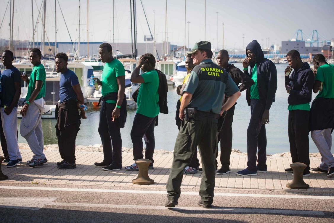 This file photo taken on June 02, 2017 shows a group of migrants lining up after arriving at the Algeciras port following their rescue by the Salvamar Atria Salvage vessel off the Strait of Gibraltar coast. Spain could overtake Greece this year in the number of migrants arriving by sea, the International Organization for Migration (IOM) said on August 10, 2017, coming shore on boats and even jet-skis. (AFP)