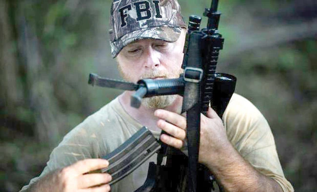 Chris Hill, founder of the Georgia Security Force militia, loads a rifle during a field training exercise. (AFP)
