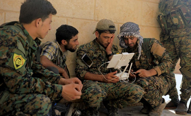 Members of the Syrian Democratic Forces control the monitor of their drone at their advanced position, during recent fighting with Daesh in Nazlat Shahada, a district of Raqqa. (Reuters)