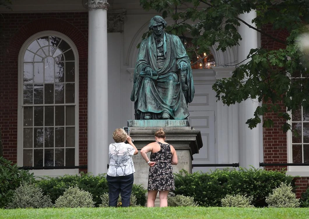 Two women take pictures in front of the statue of US Supreme Court Chief Justice Roger Brooke Taney that sits in front of the Maryland State House, on August 16, 2017 in Annapolis, Maryland. Maryland Governor Larry Hogan has called for the removal of the statue. Taney was the author of the Dred Scott decision. (AFP)