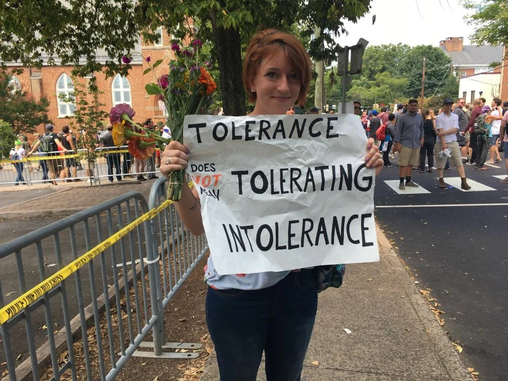 Colleen Cook, 26, holds a sign as hundreds of people are facing off in Charlottesville, Va., ahead of a white nationalist rally planned in the Virginia city's downtown, Saturday, Aug. 12, 2017. Cook, a teacher who attended UVA, said she sent her black son out of town for the weekend. "This isn't how he should have to grow up," she said. (AP)