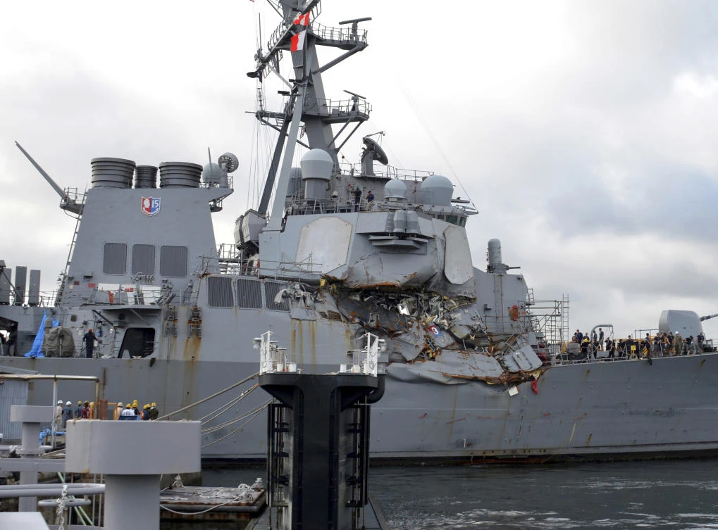 In this July 11, 2017 photo provided by U.S. Navy Office of Information, the Arleigh Burke-class guided-missile destroyer USS Fitzgerald (DDG 62) moves into Dry Dock 4 at Fleet Activities (FLEACT) Yokosuka, Japan, to continue repairs and assess damage sustained from its June 17 collision with a merchant vessel. Poor seamanship and flaws in keeping watch contributed to a collision between the Navy destroyer and a commercial container ship that killed seven sailors, Navy officials said, announcing that the warship captain will be relieved of command and more than a dozen other sailors will be punished. Adm. William Moran, the vice chief of naval operations, told reporters Thursday, Aug. 17, 2017, that the top three leaders aboard the USS Fitzgerald, which was badly damaged in the collision off the coast of Japan, will be removed from duty aboard the ship. (Mass Communication Specialist 1st Class Peter Burghart/U.S. Navy photo via AP)