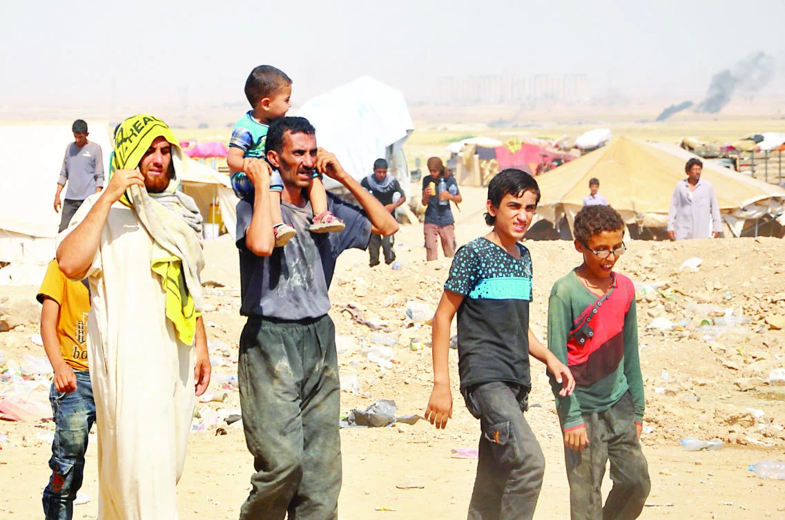 Displaced Syrians from Deir Ezzor walk at a makeshift camp, some 7 km from Arisha in the neighboring province of Hasakah on Aug. 13. (AFP)