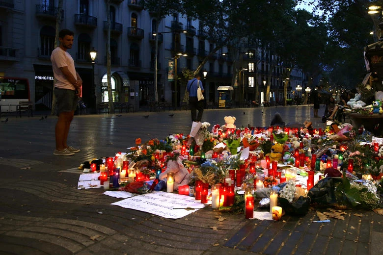 A man looks at flags, messages and candles placed after van attack that killed at least 13, in central Barcelona, Spain, Saturday, Aug. 19, 2017. Police on Friday shot and killed five people carrying bomb belts who were connected to the Barcelona van attack, as the manhunt intensified for the perpetrators of Europe's latest rampage claimed by the Islamic State group. (AP)