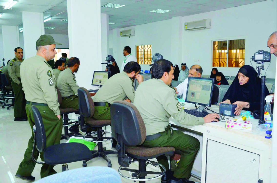 Saudi passport control officers serve Iraqi pilgrims at the Jadidah Arar border crossing on the Saudi-Iraqi border on Friday. (SPA)