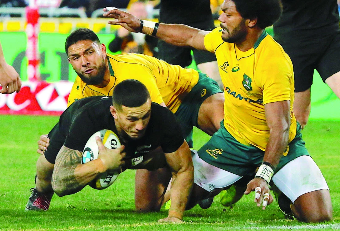 New Zealand All Blacks player Sonny Bill Williams dives to score a try as Australian Wallabies players Curtis Rona and Henry Speight try to tackle him. (Reuters)