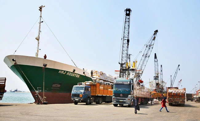 In this Aug. 9, 2017 photo, cranes offload hay from a ship onto waiting trucks in the port of the northern city of Tripoli, Lebanon. (AP)