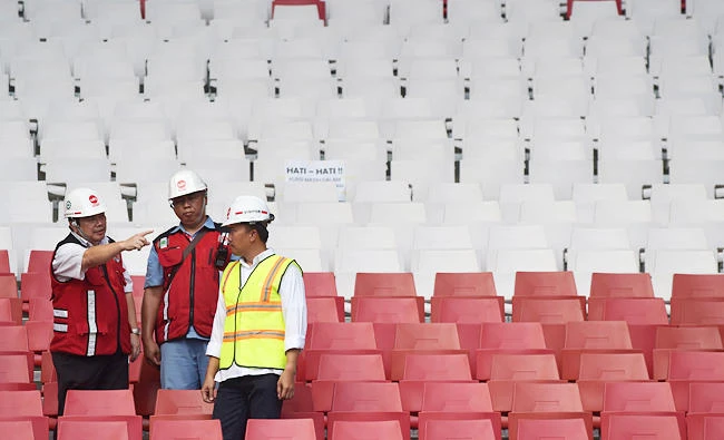 This photo taken on August 8, 2017 shows Indonesian Youth and Sport Minister Imam Nahrawi (R in green) checking the progress of renovation works at the Gelora Bung Karno stadium in Jakarta, ahead of the 2018 Asian Games. (AFP)