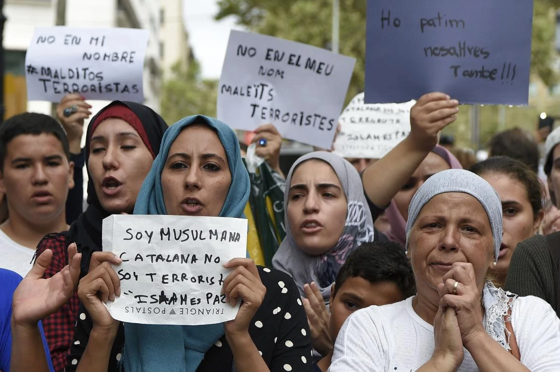 Muslim residents of Barcelona hold messages reading “I am a muslim Catalan, i am not a terrorist. Islam is peace” or “We are also afraid” as they demonstrate on the Las Ramblas boulevard in Barcelona, on August 19, 2017. (File Photo by AFP)