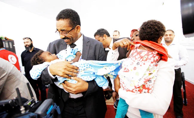 Members of Libyan Red Crescent hand over the children of Sudanese Daesh members who operated in Libya, to a Sudanese official, in Misrata, Libya on Sunday. (REUTERS)